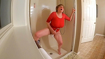 Mãe de 60+ de camiseta, se masturbando no chuveiro e gozando