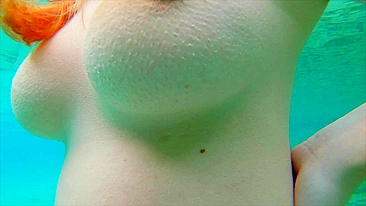 Adolescente curvilínea ruiva nada nua e mija no mar.