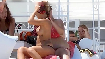 Gostosas sem sutiã pegando sol na praia arenosa