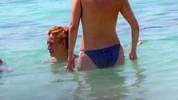 Mulheres sem sutiã de biquíni bronzeadas provocam na praia quente de Ibiza