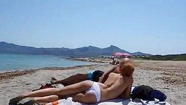 Loirinha chupa pau na praia com gente ao redor