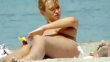 Gostosa de Peitos Grandes se Besunta de Óleo na Praia